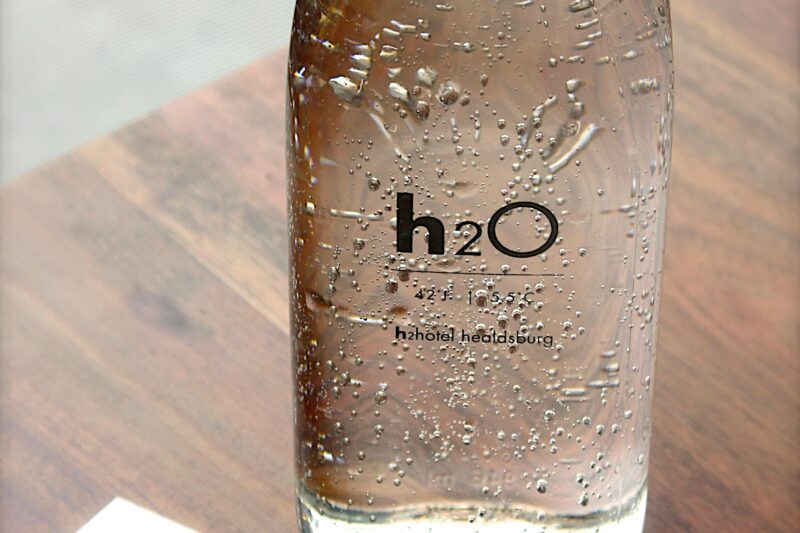 Close-up of a sparkling water bottle on a wooden table, refreshing and hydrating.